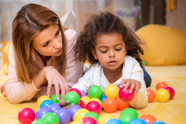 Tuteur Adorable Enfant Afro Américain Jouer Avec Des Boules Colorées — Photo