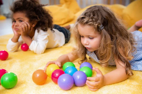 Adorável Crianças Multiétnicas Jogando Tapete Amarelo Com Bolas Coloridas Jardim — Fotografia de Stock