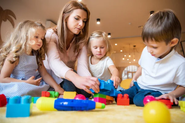 Erzieherin Und Liebenswerte Kinder Spielen Mit Bauarbeiter Kindergarten — Stockfoto