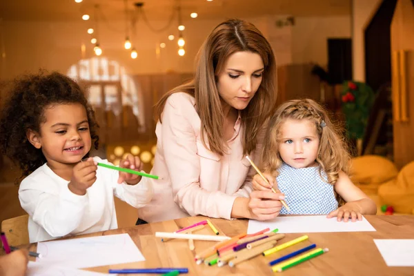 Opvoeder Helpen Multiculturele Kinderen Tekenen Kleuterschool — Gratis stockfoto