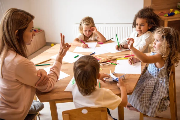 Lärare Undervisning Bedårande Mångkulturella Barn Räknar Och Visar Nummer Med — Stockfoto