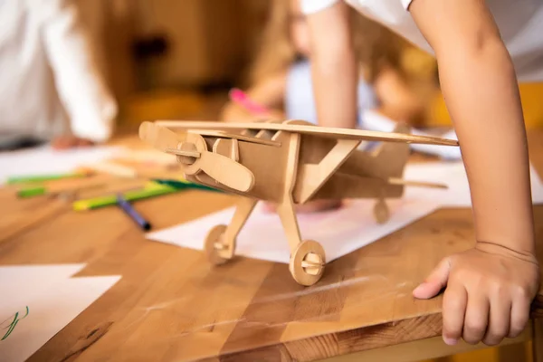 子供の幼稚園 前景には木製の飛行機の図面 — ストック写真