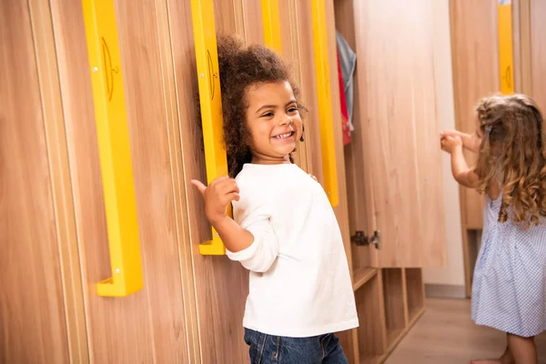 Glimlachend Multiculturele Kinderen Staande Buurt Van Kluisjes Garderobe Van Kleuterschool — Gratis stockfoto