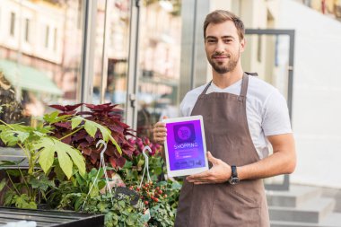yakışıklı çiçekçi holding tablet cihaz çiçekçi dükkanı yakınındaki alışveriş