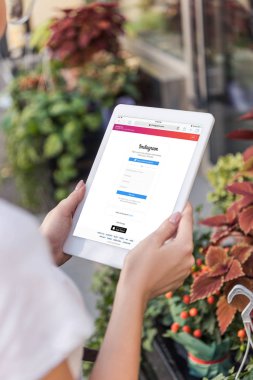Çiçekçi çiçekçi dükkanı yakınındaki yüklü instagram sayfayla tablet kullanarak kırpılmış görüntü