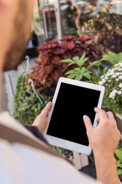 Çiçekçi çiçekçi dükkanı yakınındaki boş ekran ile tablet kullanarak kırpılmış görüntü