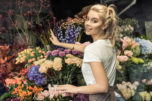 Glimlachend Aantrekkelijke Bloemist Verzorgen Van Bloemen Bloemenwinkel Camera Kijken — Stockfoto