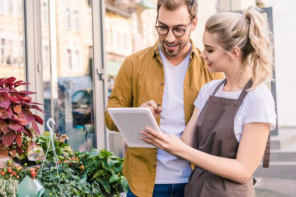 Leende Florist Och Kunden Använda Surfplatta Tillsammans Blomsteraffär — Stockfoto