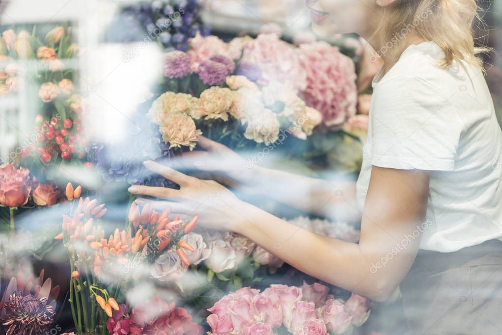 cropped image of florist taking care of bouquets in flower shop