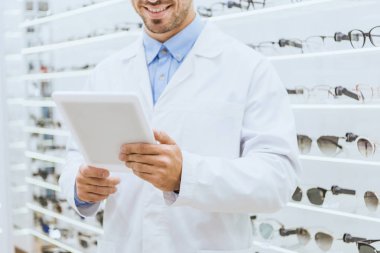 Dijital tablet optica içinde kullanma Beyaz paltolu optometrist görünümünü kırpılmış