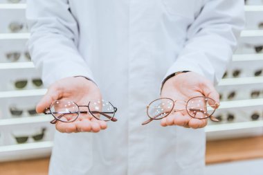 Beyaz önlük gözlük tutan Doktor görünümünü kırpılmış