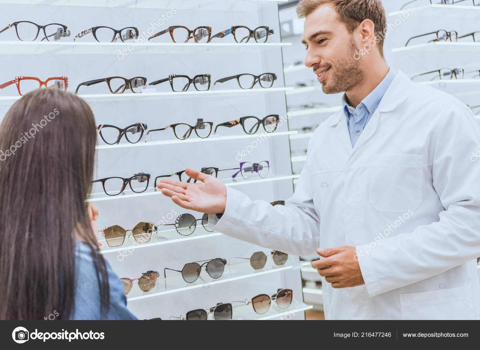 Smiling Male Oculist Pointing Hand Shelves Eyeglasses Woman Optics ...
