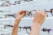 částečný pohled brát brýle z police v obchodě oční optik
