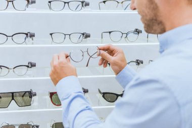 optik gözlük raflardan alarak adamın kısmi görünümü