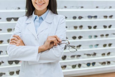 Beyaz önlük görme optica içinde tutarak profesyonel doktor görünümünü kırpılmış