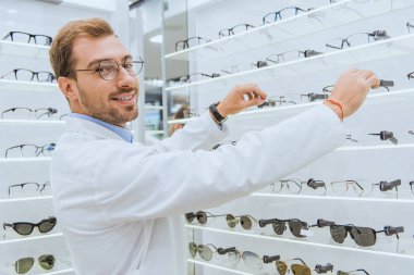gülümseyen gözlükçü görme raflardan göze ait dükkanda alarak