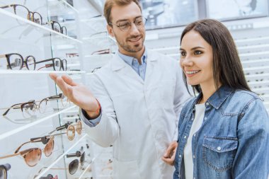 Erkek optik gözlük ile erkek düşünülmeli el ile işaret raflar