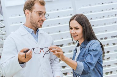 Erkek optometrist gözlük gülümseyen kadın optica olarak gösterilen seçici odak