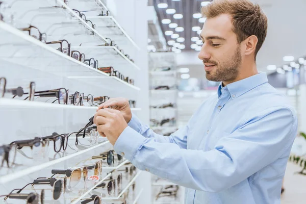 Enfoque Selectivo Joven Feliz Hombre Tomando Gafas Los Estantes Tienda — Foto de Stock