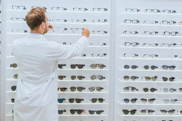 Back View Oculist White Coat Taking Glasses Shelves Ophthalmic Shop — Free Stock Photo