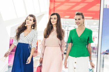 kağıt torba tutarak ve uzak alışveriş merkezinde arıyor genç kadın gülümseyerek