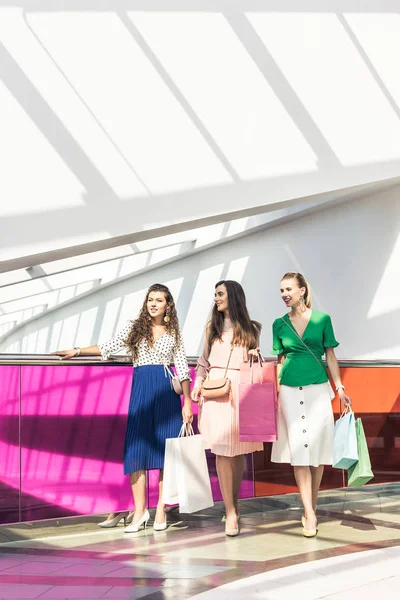 Sonrientes Chicas Moda Sosteniendo Bolsas Papel Mirando Hacia Centro Comercial —  Fotos de Stock