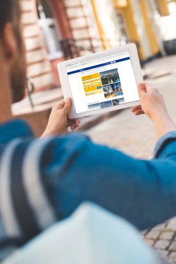 Genç adam tarafından sokakta yürürken rezervasyon web sitesinde ekran tablet kullanarak atış kırpılmış