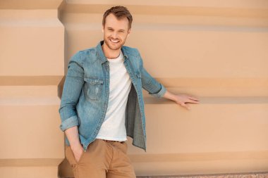 yakışıklı genç Caddesi üzerinde Binası duvara yaslanmış ve kameraya bakarak adam