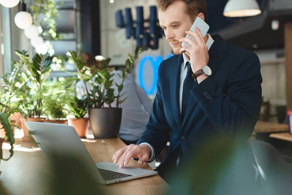 Hombre Negocios Traje Hablando Teléfono Inteligente Mientras Trabaja Distancia Ordenador — Foto de Stock