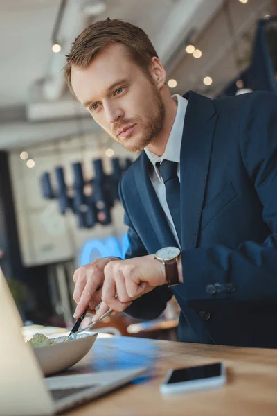 Бізнесмен Дивиться Екран Ноутбука Обідаючи Кафе — Безкоштовне стокове фото