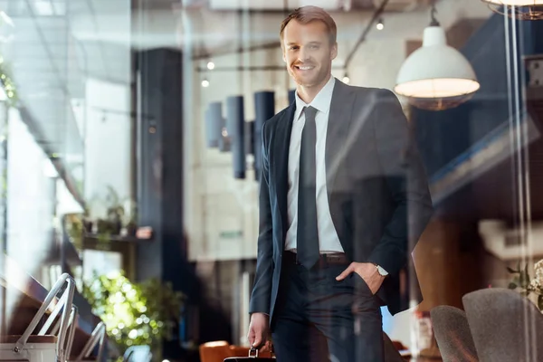 Retrato Hombre Negocios Sonriente Con Maleta Mirando Cámara Restaurante — Foto de stock gratis