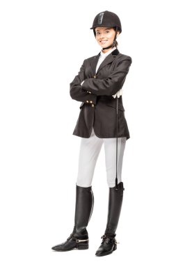 happy young horsewoman in uniform holding horseman stick and looking at camera isolated on white clipart