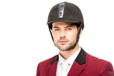close-up portrait of handsome young horseman in uniform and helmet looking at camera isolated on white clipart