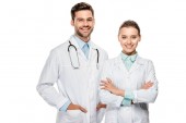 hezký šťastný lékař stojící poblíž kolegyně s překřížením rukou izolované na bílém 