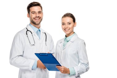happy female doctor holding clipboard while her male colleague standing near isolated on white  clipart