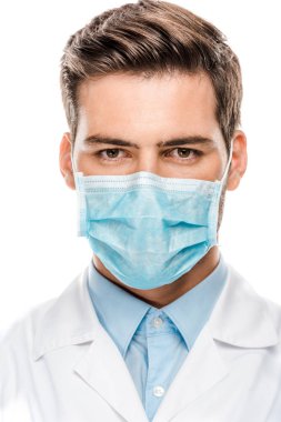ciddi genç erkek Doktor tıbbi maske üzerinde beyaz izole kamera bakıyor 