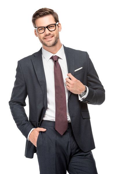 cheerful handsome young businessman in jacket and eyeglasses isolated on white