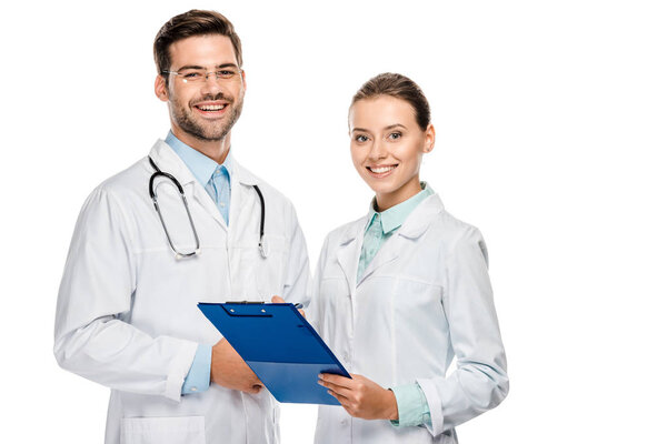 happy female doctor holding clipboard while her male colleague standing near isolated on white 