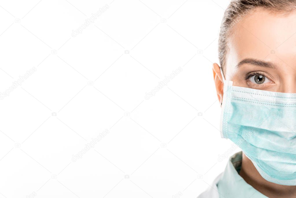 cropped image of young female doctor in medical mask looking at camera isolated on white