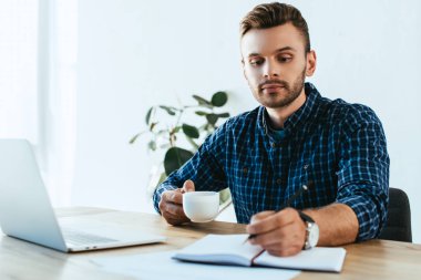 genç işadamı masa ofis dizüstü bilgisayar ile webinar yılında katılan sırasında Notlar yapma