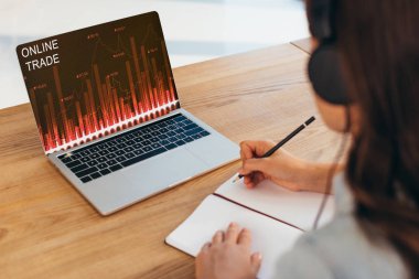 kısmi işkadını defter ve laptop ile online ticaret yazı ile işyerinde oturan kulaklıklar görünümünü 
