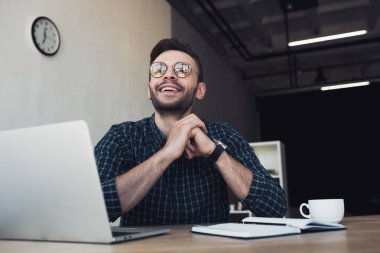 laptop ve defter Office ile işyerinde gülümseyen işadamı portresi