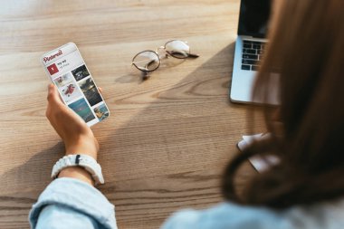 işkadını pinterest logosu ile smartphone ile kısmi görünümü ekran dizüstü bilgisayarda işyerinde çalışma