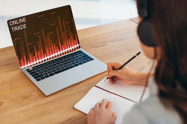 Sebagian Pandangan Pengusaha Dalam Headphone Duduk Tempat Kerja Dengan Notebook — Foto Stok Gratis