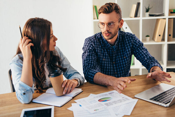 business colleagues taking part in webinar together at workplace with papers and notebook in office