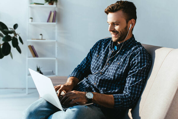 smiling man in earphones taking part in webinar at home