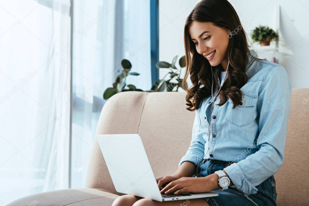 young smiling woman on sofa taking part in webinar at home