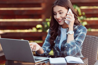 neşeli kadın, Masa laptop ve defter ile smartphone üzerinde söz