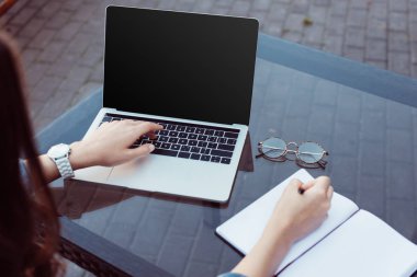 Sokak kafede masada boş ekranlı dizüstü bilgisayar kullanan kız kırpılmış görüntü