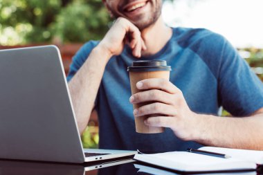 kırpılmış görüntü gülümseyen adam webinar mekanlarda yer alan ve tek kullanımlık kahve fincanı holding